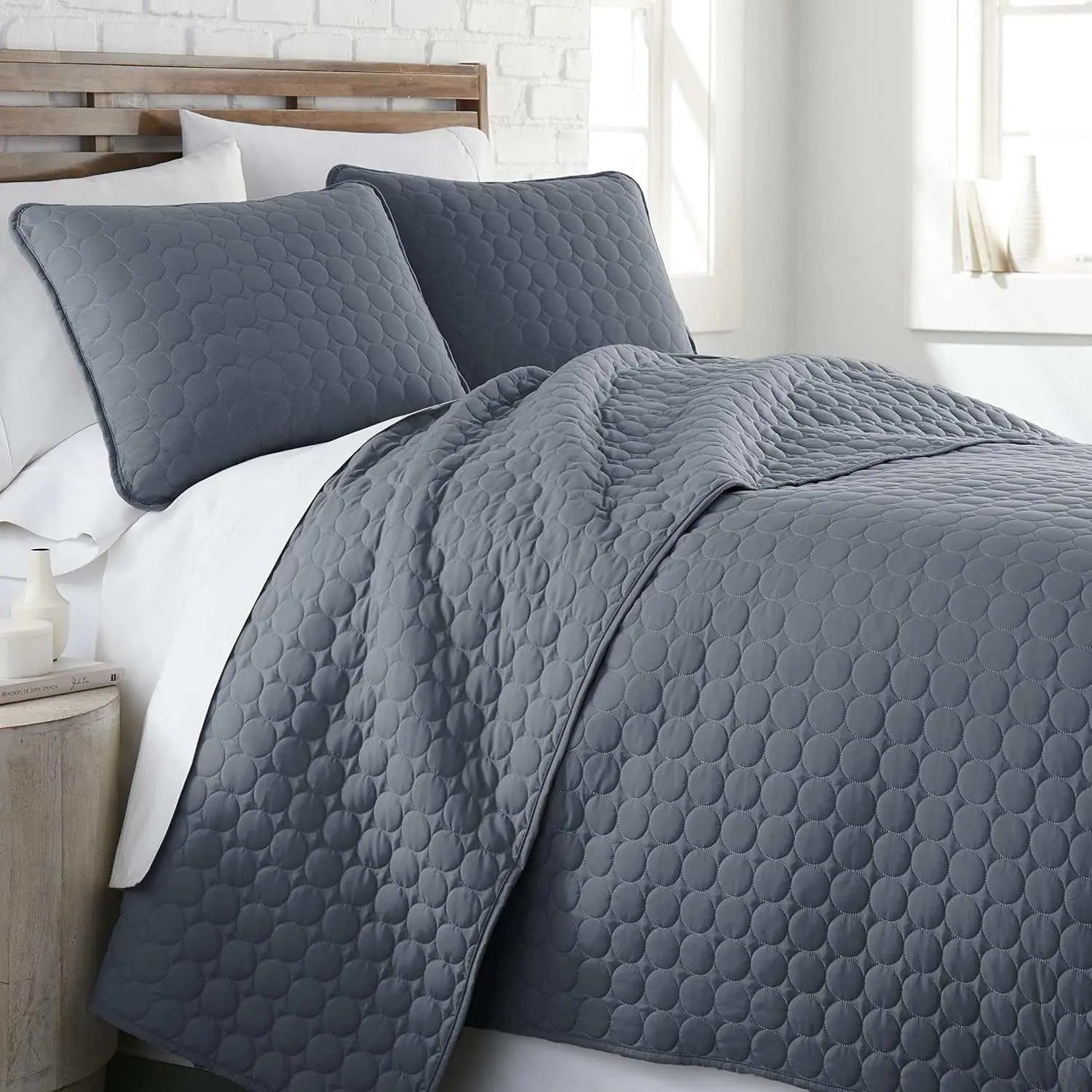 Full queen quilt bedding set in blue with circle stitching, including quilt and matching pillow shams on a bed.