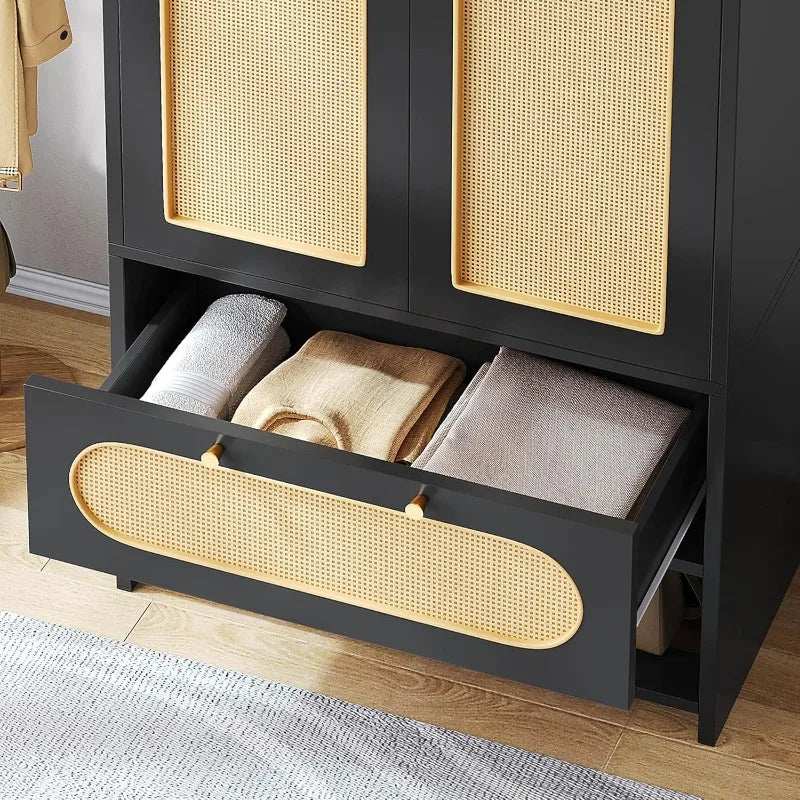 Black rattan armoire wardrobe with woven doors and drawer storing folded blankets.