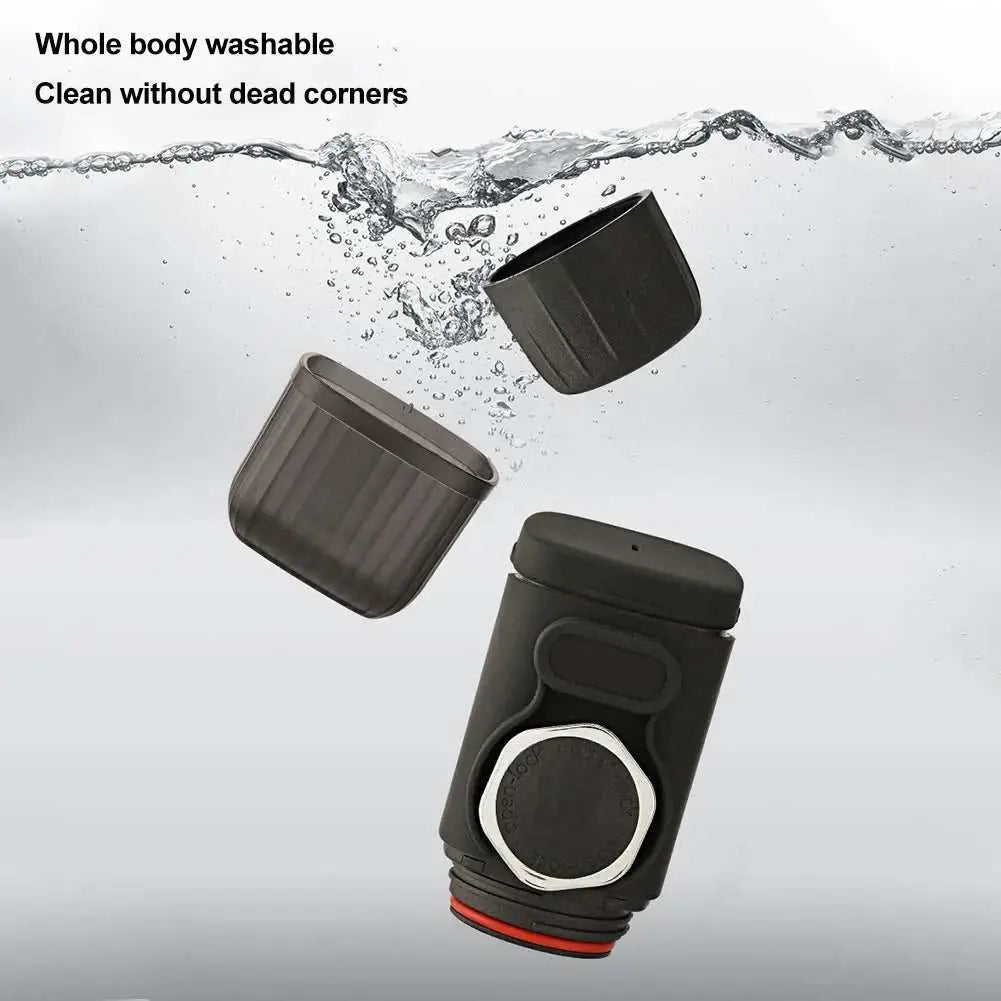 Portable black mini manual espresso maker disassembled and submerged in water for easy cleaning demonstration