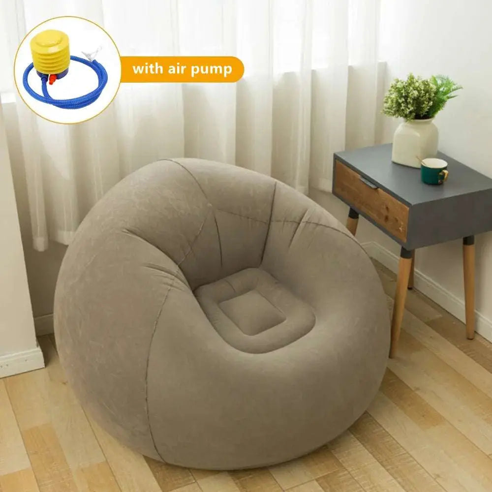Large lazy inflatable sofa chair in beige flocking PVC with air pump in living room setting next to wooden side table