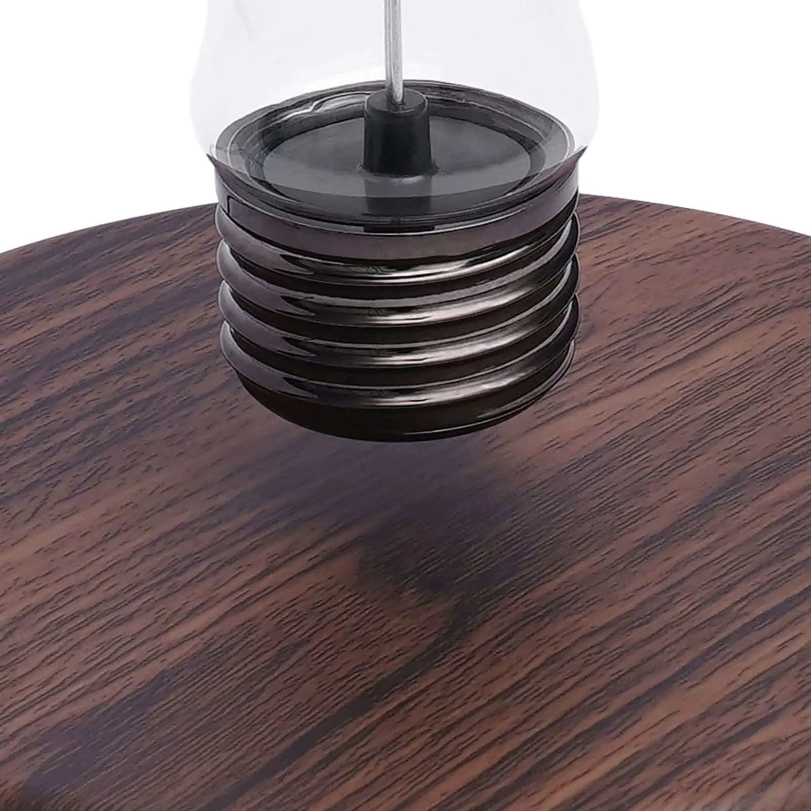 Close-up of magnetic levitating light bulb suspended over a wooden base, showcasing anti-gravity floating lamp design.