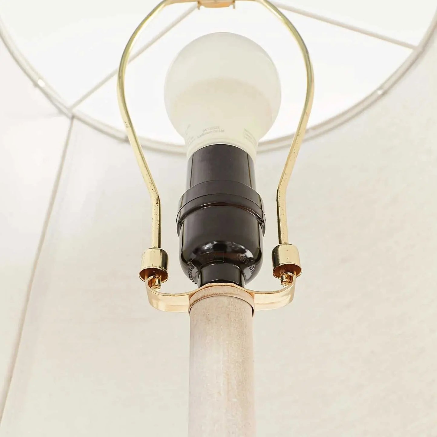 Close-up of a coastal candlestick table lamp with LED bulb and white fabric shade interior