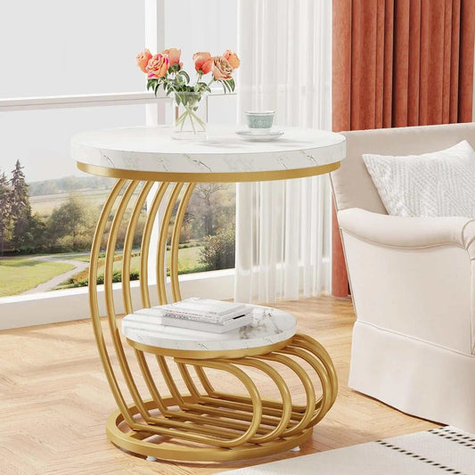 Modern round end side table with two marble-look tiers and gold arc-shaped metal frame, placed in a bright living room next to a white armchair.