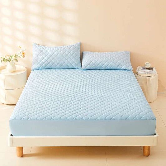 Blue 3D Air Fabric quilted mattress cover fitted on bed with two pillows in bright room