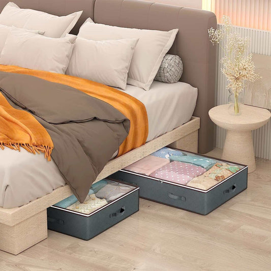 Set of 4 grey under bed storage bags with clear windows, fabric material, stainless steel zippers, and reinforced handles, shown under a bed storing clothes and blankets.