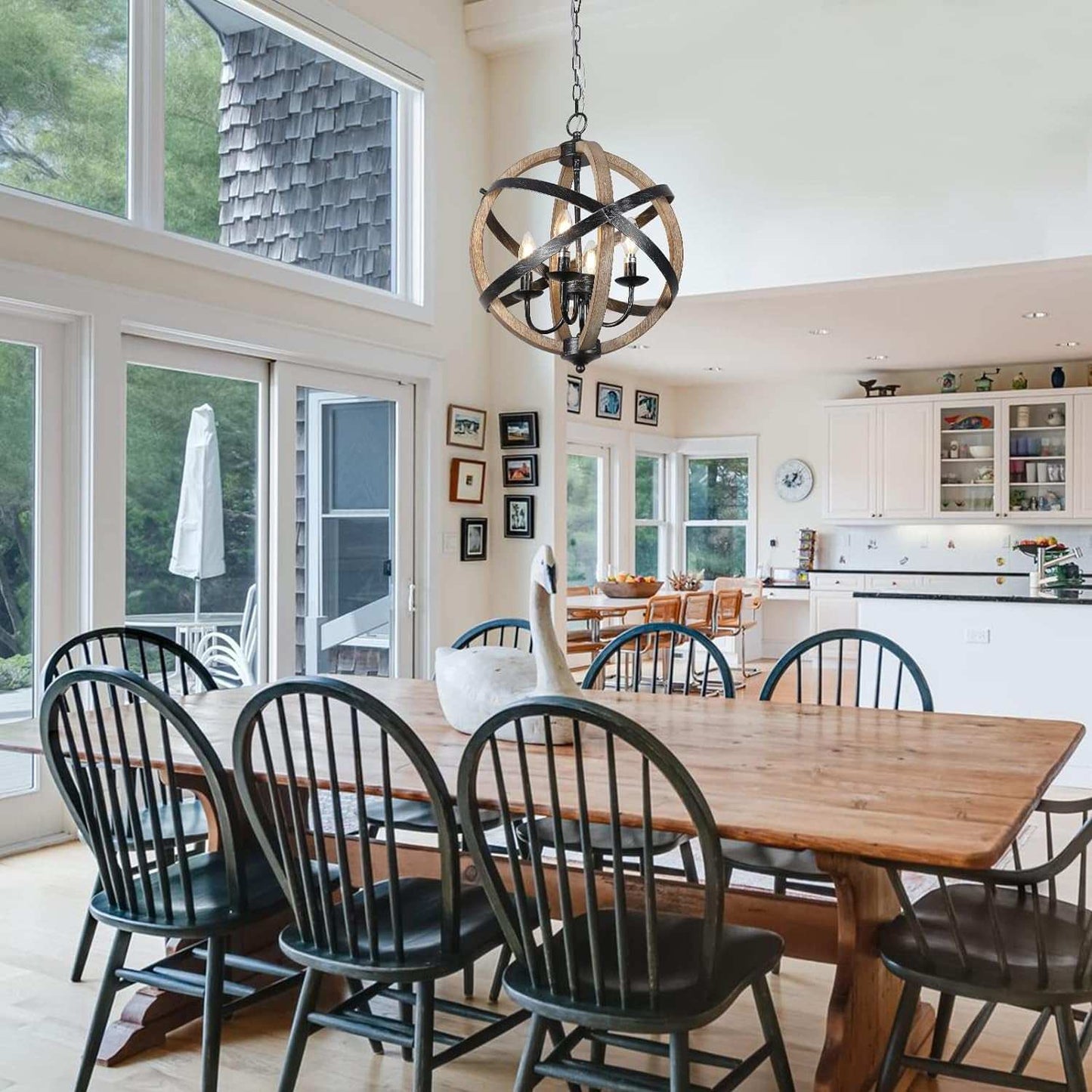 Farmhouse chandelier lamp with wood and metal design hanging above a wooden dining table in a bright modern kitchen.