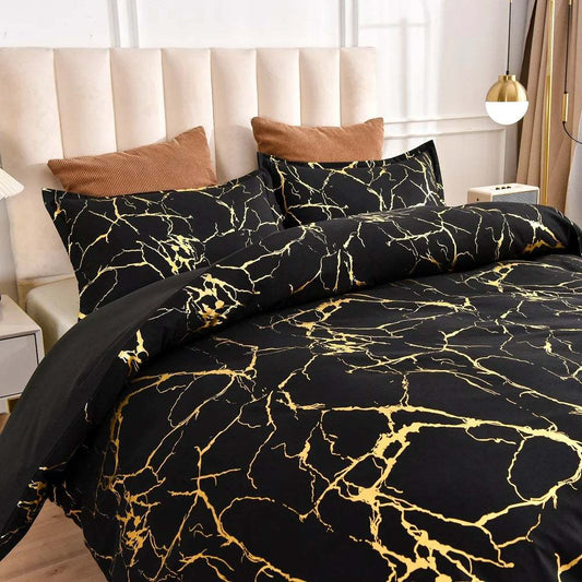 Black gold metallic marble pattern satin bedding set on bed with beige headboard and brown pillows