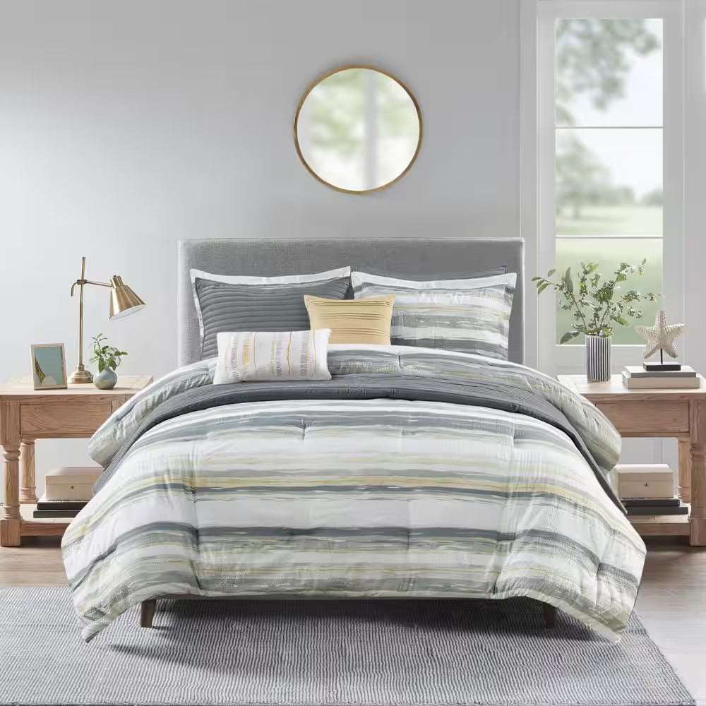 Anchorage 8-Piece Comforter Set with textured seersucker, watercolor stripe print in yellow and gray, including comforter, shams, decorative pillows, and quilt on modern bed.