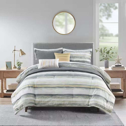 Anchorage 8-Piece Comforter Set with textured seersucker, watercolor stripe print in yellow and gray, including comforter, shams, decorative pillows, and quilt on modern bed.