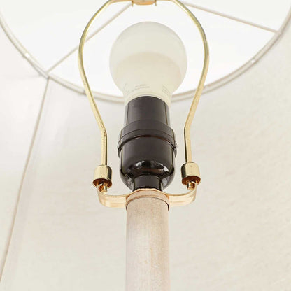 Close-up of a coastal candlestick table lamp with LED bulb and white fabric shade interior